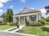 Charming one-story home with a well-manicured lawn and inviting front porch with white columns at 4148 Cedar Point Ave, Matthews, NC 28104