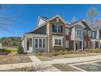 Attractive townhome with brick and siding, manicured landscaping, and sidewalk at 1111 Johns Walk Way, Belmont, NC 28012
