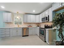 Well-lit kitchen featuring stainless steel appliances, white cabinets, and sleek countertops at 220 E Bell St # 7, Statesville, NC 28677