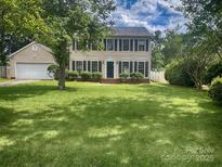 Traditional two-story home with a large front yard, manicured landscaping, and an attached two-car garage at 443 Silversmith Ln, Charlotte, NC 28270