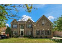 Beautiful brick home with manicured lawn, classic shutters, and arched entryway, offering timeless curb appeal at 7605 Berryfield Ct, Waxhaw, NC 28173