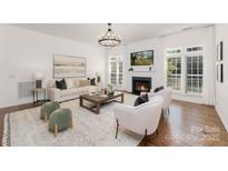 Bright living room with fireplace, hardwood floors, and large windows for natural light at 7605 Berryfield Ct, Waxhaw, NC 28173