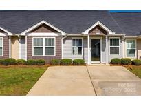 Charming home featuring manicured front yard, driveway, and inviting entryway at 104 S Canyon Rdg, Mount Holly, NC 28120