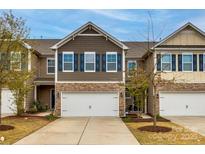 Charming townhome with a two-car garage, stone accents, and blue shutters at 1211 Croft Dr, Fort Mill, SC 29708