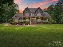 Charming two-story home with a stone facade, inviting front porch, and manicured lawn at 217 Blossom Hill Rd, Lincolnton, NC 28092