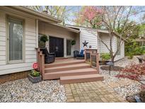 Charming home exterior features a wooden porch, double front doors, and a stone walkway, framed by flowering trees at 27 Heritage Ct, Lake Wylie, SC 29710