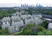Stunning aerial view of modern townhomes with the city skyline in the background at 327 Uptown West Dr, Charlotte, NC 28208