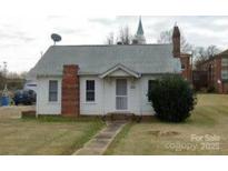 Charming one-story home with brick chimney, covered entry, and mature landscaping at 502 And 504 Church St, Belmont, NC 28012
