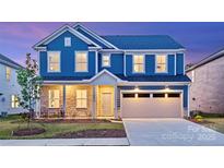 Charming two-story blue home featuring a two-car garage, stone accents, and a well-manicured lawn at 6020 Chumbley Point Rd # 73, Charlotte, NC 28215