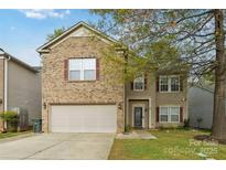 Charming two-story home with brick and vinyl siding, showcasing a well-maintained front yard and a two-car garage at 707 Sinclair Dr, Monroe, NC 28112