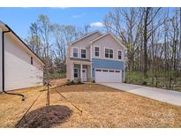 Charming two-story home featuring a two-car garage, blue and gray siding, and a well-manicured front yard at 7444 Malabar Rd # 14, Huntersville, NC 28078