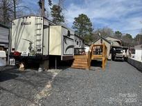Exterior of RV with steps, deck, ladder, and small cottage in RV community with gravel at 120 Cherokee Trl, Mount Gilead, NC 27306