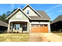 Charming craftsman-style home with a beautiful wood garage door and stone-accented porch at 182 Fulworth Nw Dr # 63, Concord, NC 28027