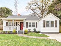 Charming single-Gathering home featuring a well-manicured lawn, quaint porch, and bright red front door at 2843 Cowles Rd, Charlotte, NC 28208