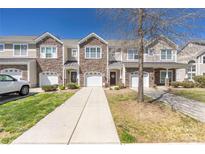 Beautiful townhome exterior featuring a stone facade, attached garages, and well-maintained landscaping on a sunny day at 4644 Craigmoss Ln, Charlotte, NC 28278
