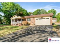Charming single-story brick home with an attached two-car garage and covered front porch at 552 Odell School Rd, Concord, NC 28027