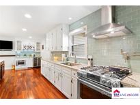Modern kitchen features stainless steel appliances, light cabinetry, and lovely tile backsplash at 552 Odell School Rd, Concord, NC 28027
