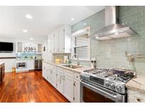 Modern kitchen boasts stainless steel appliances, granite countertops, and a stylish tile backsplash at 552 Odell School Rd, Concord, NC 28027