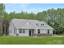 Charming single-story home with stone accents and a well-manicured lawn at 700 Sunset Pointe Dr, Salisbury, NC 28146