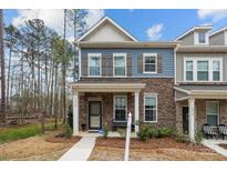 Charming townhome with a stone and blue siding exterior and a cozy front porch at 7918 Nelson Rd, Mint Hill, NC 92227