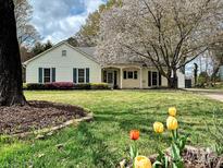 Charming home featuring lush green lawn, flowering trees and colorful spring tulips at 8604 Doe Run Rd, Charlotte, NC 28277