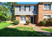 Charming two-story townhouse with a brick facade, black shutters, and a well-maintained front lawn at 1205 Scaleybark Rd # A, Charlotte, NC 28209