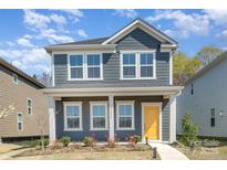 Charming two-story home with a welcoming yellow front door and beautiful landscaping at 15616 Parkside Crossing Dr, Charlotte, NC 28278