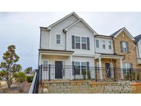 Charming two-story home features a black metal fence, neutral siding and trim, and an inviting facade at 1814 Saint Louis Nw Aly, Concord, NC 28027