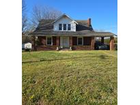 Charming red brick two-story home with a covered porch and carport, set on a grassy lot at 307 Gold Hill Ave, Rockwell, NC 28138