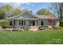 Charming brick home features a manicured lawn and lush landscaping in front at 3614 Champaign St, Charlotte, NC 28210