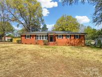 Charming brick home with mature trees, manicured landscaping, and a well-maintained front yard at 4331 Hamilton Cir, Charlotte, NC 28216