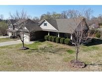 Charming brick home with mature landscaping and well-maintained lawn at 7283 Bradberry Ln, Denver, NC 28037