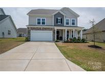 Charming two-story home with stone accents, covered porch, well-kept lawn, and a spacious driveway at 7924 Creek Park Dr, Denver, NC 28037