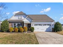 Charming single-story home featuring a manicured lawn, stone accents, and an attached two-car garage at 103 Karlyn Ct, Mooresville, NC 28115