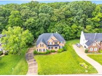 Stunning traditional brick home boasts lush landscaping and a winding driveway, nestled amongst mature trees at 1102 High Brook Dr, Waxhaw, NC 28173