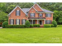 Charming brick two-story home with a well-manicured lawn and neatly trimmed hedges at 1102 High Brook Dr, Waxhaw, NC 28173