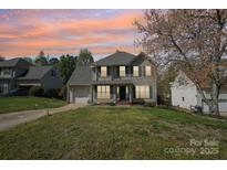 Charming two-story home with attached garage, lawn, and professional landscaping at 11615 Hidden Grove Trl, Charlotte, NC 28215