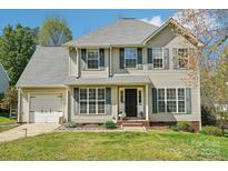 Charming two-story home featuring a well-manicured lawn and attached garage at 11615 Hidden Grove Trl, Charlotte, NC 28215