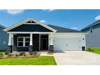 Charming single-Gathering home with stone accents, white siding, manicured lawn, and two-car garage on a sunny day at 1234 Morehead Dr, Salisbury, NC 28144