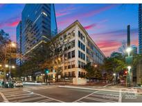 An inviting street view of a building at dusk, showcasing its architecture and bustling surroundings at 127 N Tryon St # 615, Charlotte, NC 28202