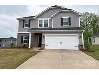 Charming two-story home with gray siding, brick accents, and a spacious two-car garage at 1986 Paddlewheel Dr, Stanley, NC 28164