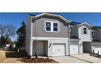 Charming two-story townhome with white siding, gray accents, and an attached single-car garage at 2070 Old Rivers Rd, Concord, NC 28027