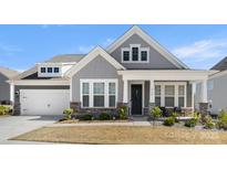Charming two-story home featuring stone accents, a covered porch, and a well-manicured lawn at 2768 Suffolk Pl, Fort Mill, SC 29715