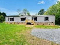 Charming one-story home with gray siding, black shutters, and a well-maintained front yard at 3144 Rickwood Dr, Newton, NC 28658