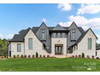 Stunning two-story home featuring a light-colored brick facade, gabled roof, and expansive front lawn at 406 Sugar Maple Ln, Weddington, NC 28104