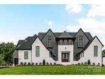 Stunning new construction features a stylish white brick and gray exterior with a beautifully manicured lawn at 406 Sugar Maple Ln, Weddington, NC 28104