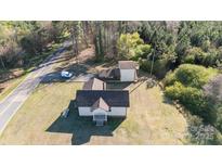 An aerial view shows a home on a large lot with several outbuildings at 6441 Highway 73 W Hwy, Mount Gilead, NC 27306