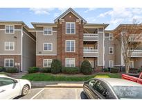 Charming condo exterior with brick accents, multiple balconies, and manicured landscaping at 9810 Campus Walk Ln # G, Charlotte, NC 28262