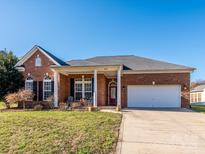 Charming single-story brick home featuring a two-car garage and beautifully landscaped front yard at 1021 Glen Laurel Dr, Fort Mill, SC 29707