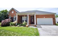 Charming brick home boasts a lush front yard, well-maintained landscaping, and inviting curb appeal at 1021 Glen Laurel Dr, Fort Mill, SC 29707
